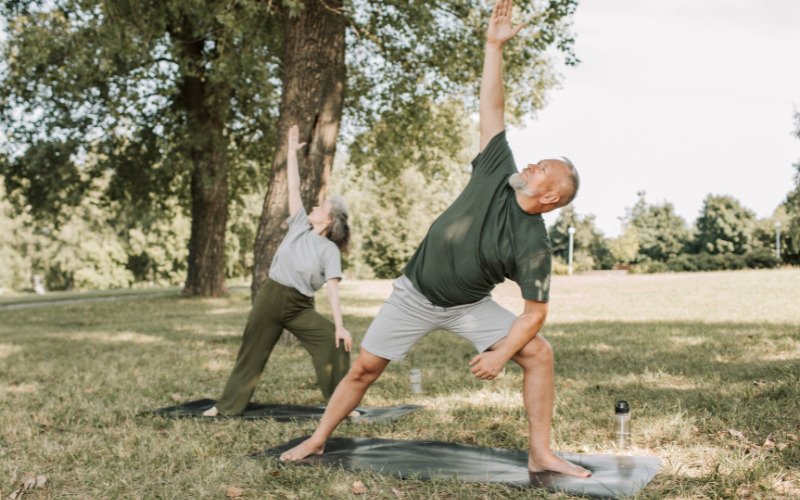 A person jogging through a lush green park with sunlight streaming through the trees, symbolizing the importance of movement in The Holistic Guide to Wellness.